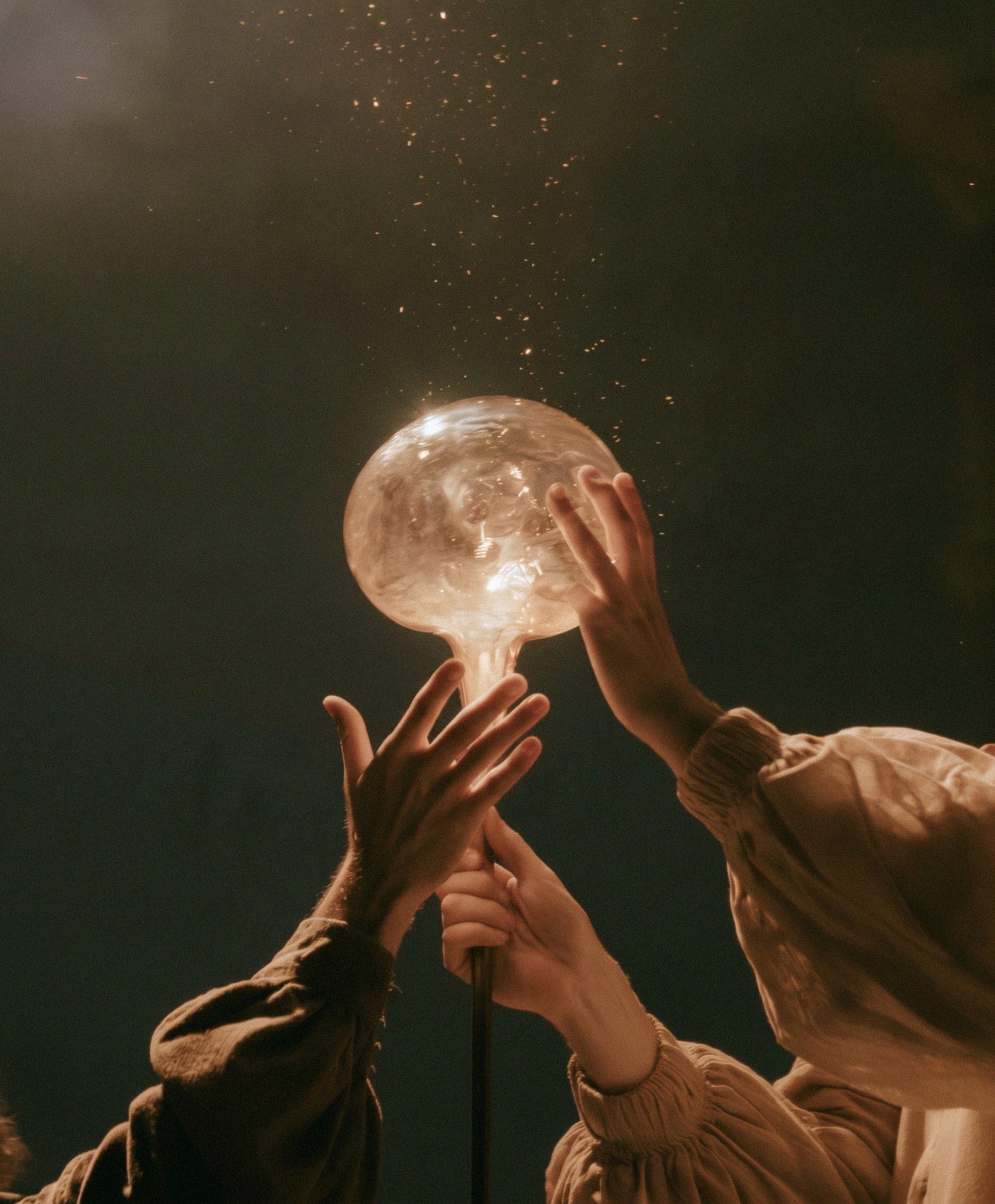 Hands around a light, at the opening